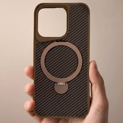 Hand holding a brown carbon fiber MagSafe iPhone case with a built-in ring stand